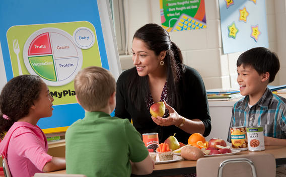 Mujer enseñando a los niños sobre una buena nutrición