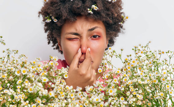 Mujer tapándose la nariz y mostrando signos de alergia al polen