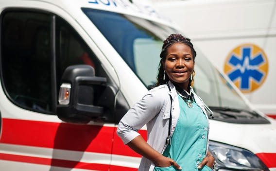 Trabajador médico de emergencia parado frente a la ambulancia