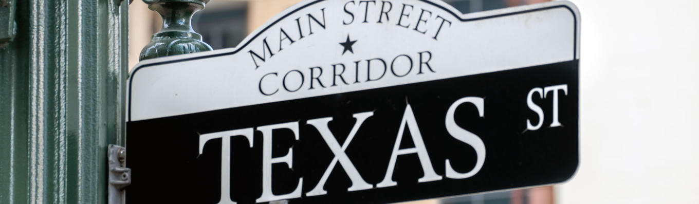 Street sign with words: Main Street Corridor Texas Street