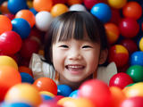 Niño jugando rodeado de coloridas bolas de plástico.
