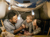 Parents with child under blanket tent